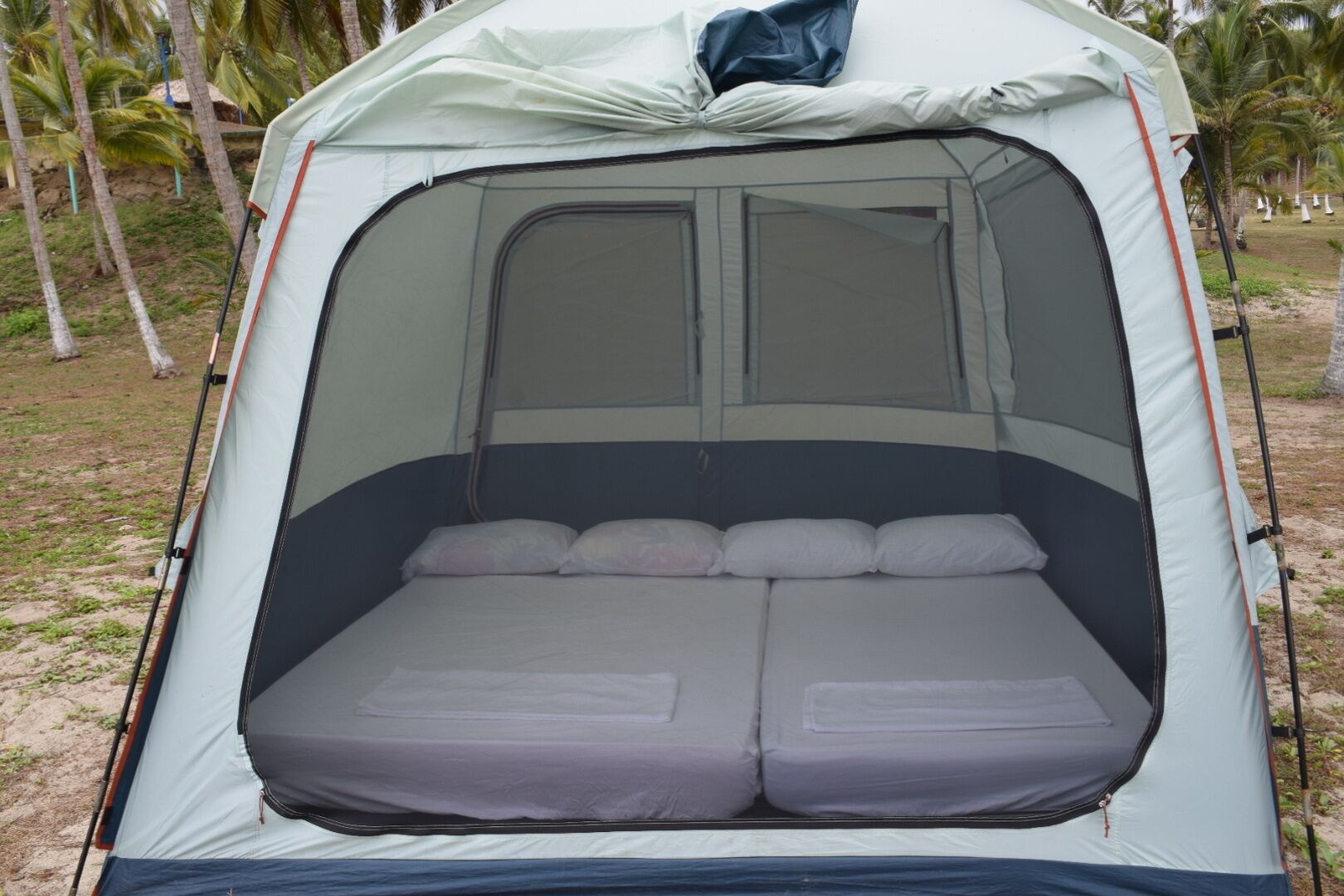 A tent with a sleeping area featuring a mattress and pillows.
