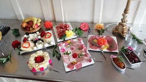 A table with various food items and flowers, a lamp, and a decorative candelabra. - Gutshof Elbschloss Kehnert (Tangerhütte)