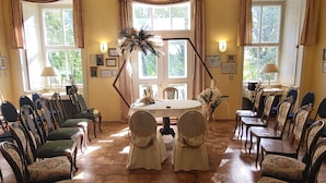 A formal dining room with a round table, chairs, and floral decorations. - Gutshof Elbschloss Kehnert (Tangerhütte)