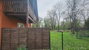 A wooden fence, a grassy area, and trees in the background. - Gutshof Elbschloss Kehnert (Tangerhütte)