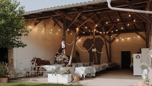 An outdoor covered patio with string lights, tables, and potted plants. - Gutshof Elbschloss Kehnert (Tangerhütte)