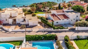 Un quartier résidentiel en bord de mer, doté d’une piscine, de bâtiments blancs et offrant une vue sur la mer.