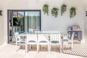 Enjoy dining al fresco in an outdoor space with a table for six and comfortable seating.