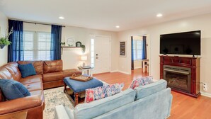 A living room with a brown leather sofa, a blue sofa, a fireplace, and a television. - Virginia Escape w/ Patio & Fire Pit, Near Hiking! (Speedwell)