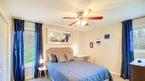 A bedroom with a bed, a ceiling fan, a bedside table with a lamp, and a window with curtains. - Virginia Escape w/ Patio & Fire Pit, Near Hiking! (Speedwell)
