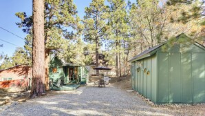 A gravel driveway leading to a green shed and a small porch area with a table and chairs. - 3 Mi to Big Bear Village: Charming Sugarloaf Cabin (Sugarloaf)