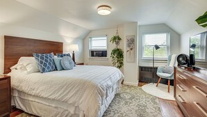 Une chambre à coucher avec un grand lit, une commode, une chaise et un bureau.