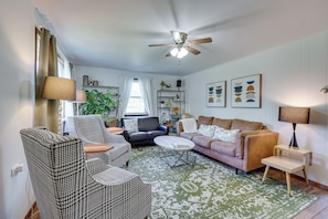 A living room with a ceiling fan, two sofas, a patterned rug, and a coffee table. - Charming Gardiner Home w/ Yard & Sunroom (Gardiner)