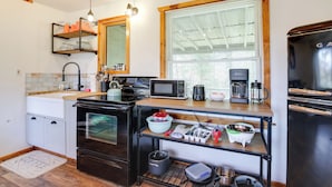 A compact kitchen with a microwave, coffee maker, and a refrigerator. - 'faith Cabin' in Cosby: Fire Pit + Covered Deck (Cosby)