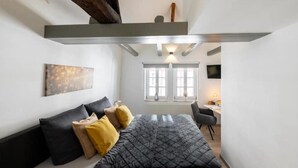 Un dormitorio pequeño con cama, escritorio y ventana.