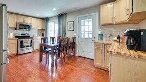 A kitchen with wooden cabinets, a dining table with chairs, a refrigerator, and a microwave. - Serene Springfield Retreat on 6 Acres w/ Hot Tub! (Springfield)
