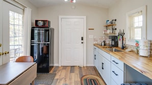 Eine kompakte Küche mit Kühlschrank, Mikrowelle und Kaffeemaschine.
