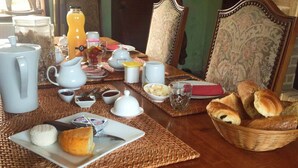 A breakfast table set with various breakfast items including bread, pastries, and beverages. - La Chambre Rouge (ECHINGHEN)