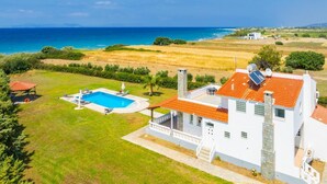 Een witte villa met zwembad en uitzicht op zee.