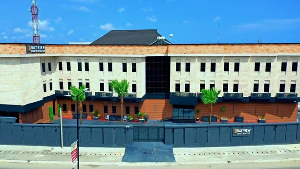 A multi-story hotel with a brick facade, multiple windows, and a central entrance. - Bayview Resorts And Hotels Lekki (Lekki)