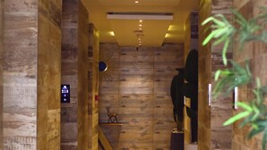 A hallway with wooden paneling, a digital display, and a small deer statue. - Bayview Resorts And Hotels Lekki (Lekki)