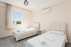 A hotel room with two beds, a window with sheer curtains, an air conditioning unit, and a marble floor. - Villa Corals - Four Bedroom Villa, Sleeps 8 (Dalyan)