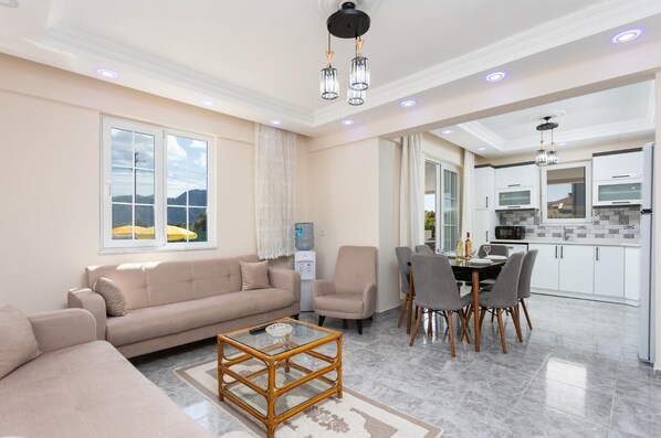 Un salon moderne avec un canapé, une table basse et un coin repas.