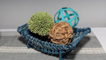 A blue woven basket containing three spherical objects on a textured fabric surface.