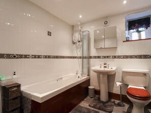 A modern bathroom with a bathtub, sink, and toilet. - West View (Morpeth)