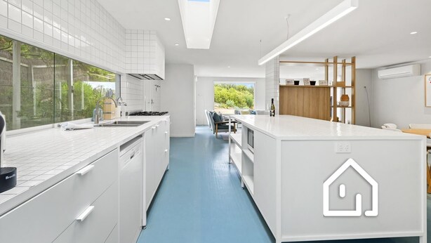 A modern kitchen with white cabinetry, a central island, and a view of the outdoors. - Villa Santorini *1 NIGHT FREE* Secluded Back Beach Poolside Oasis (Blairgowrie)