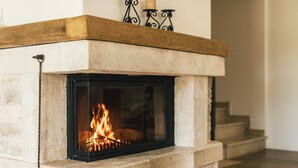 Une cheminée avec un foyer en pierre et une manteau en bois.