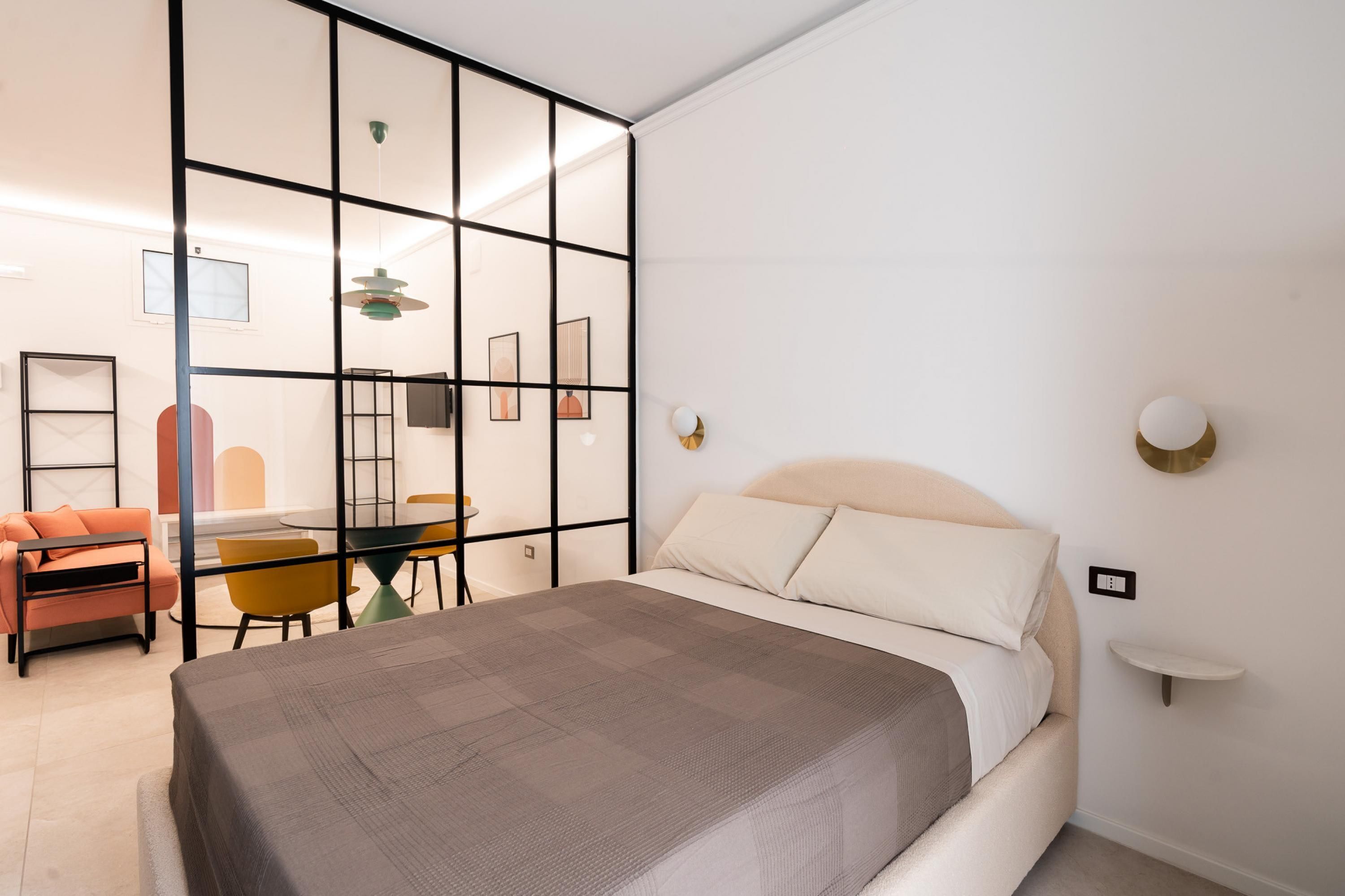 Un dormitorio moderno con una cama, un escritorio y un sofá.
