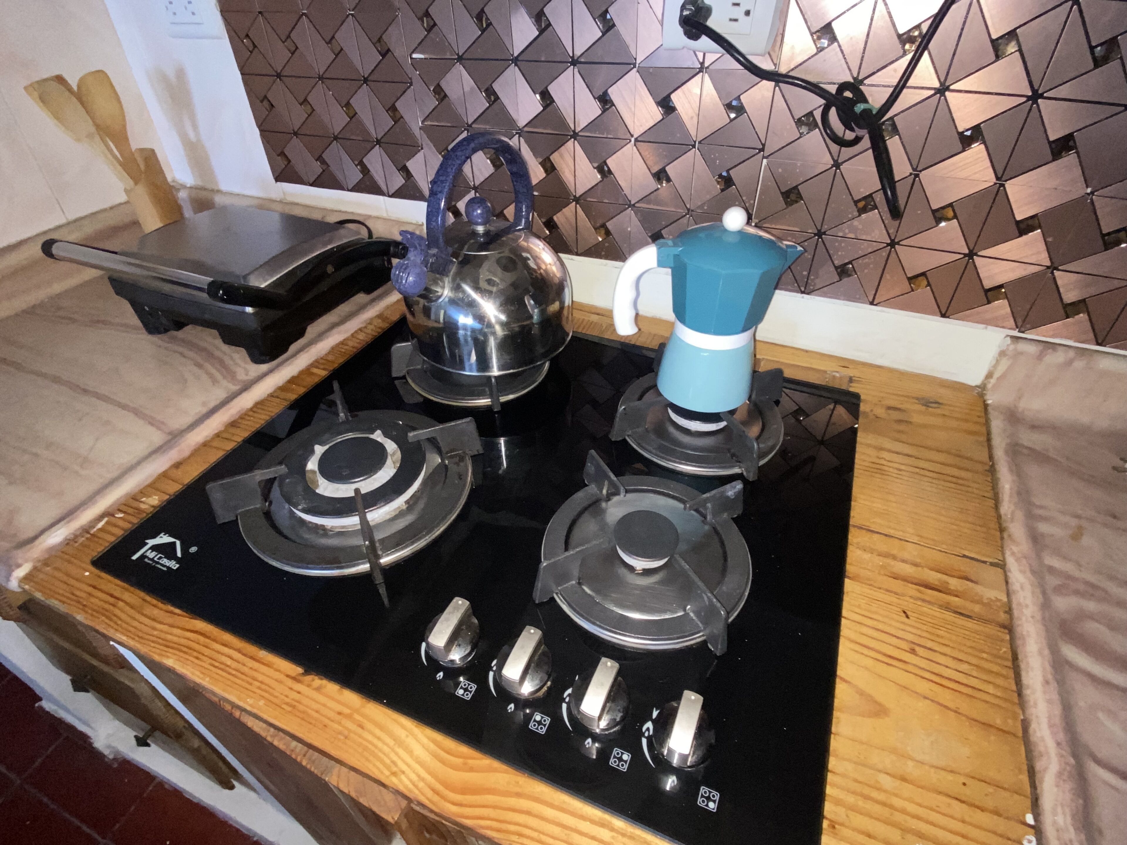 Eine Küche mit Gasherd, Wasserkocher und Kaffeemaschine.