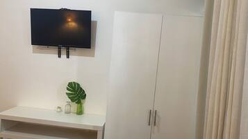 Un armario blanco con un televisor montado en la pared encima.