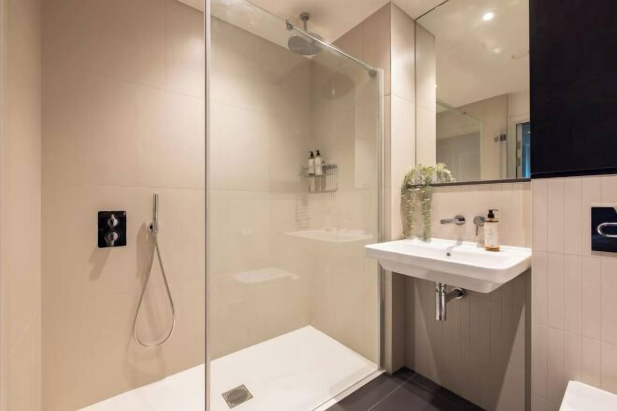 Bathroom | Rainfall showerhead, hair dryer, towels, toilet paper