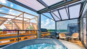 Un área de hidromasaje con vista al cielo y una terraza de madera.