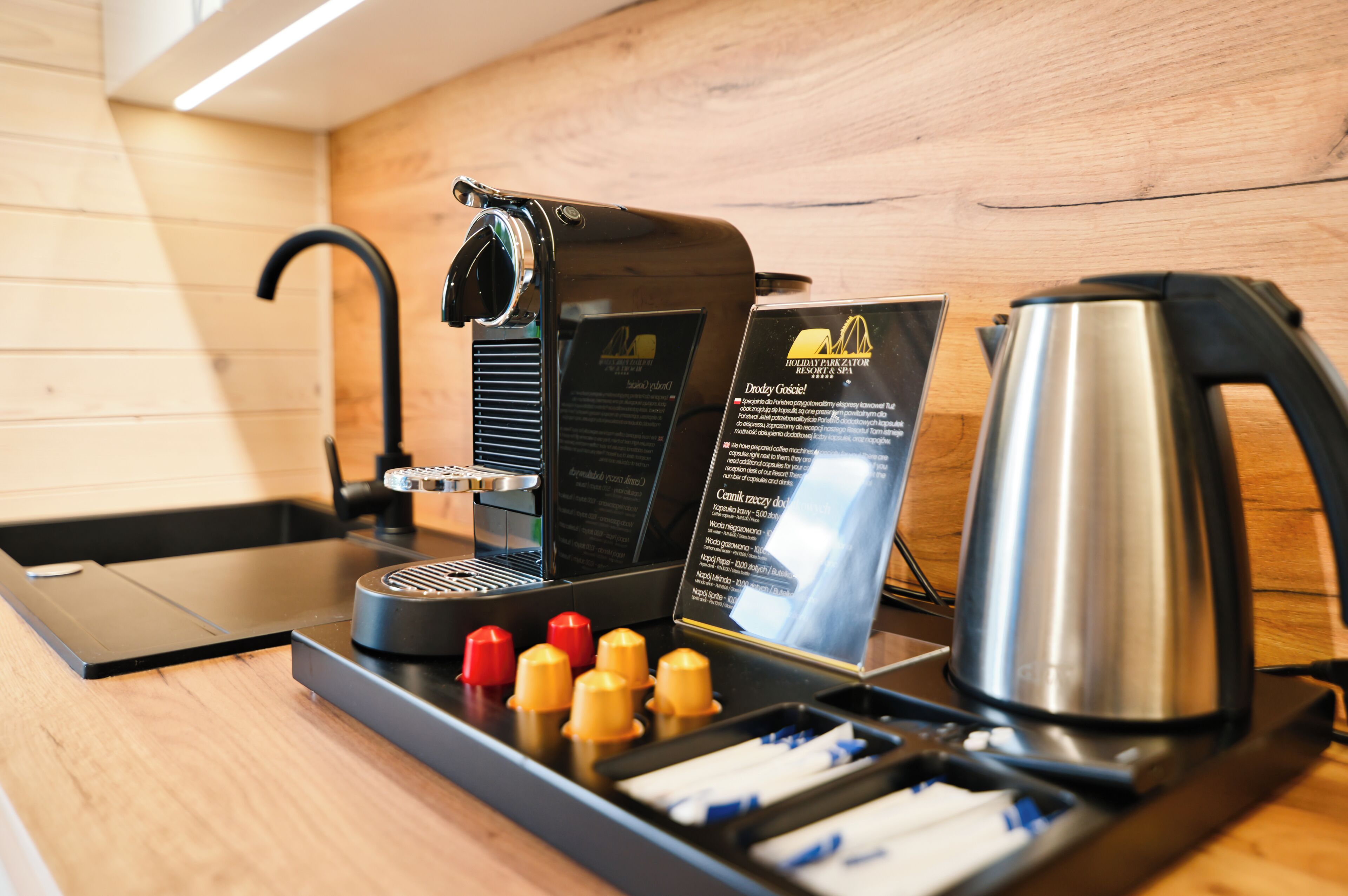 A coffee machine with a drip tray, a coffee pot, and a menu stand.