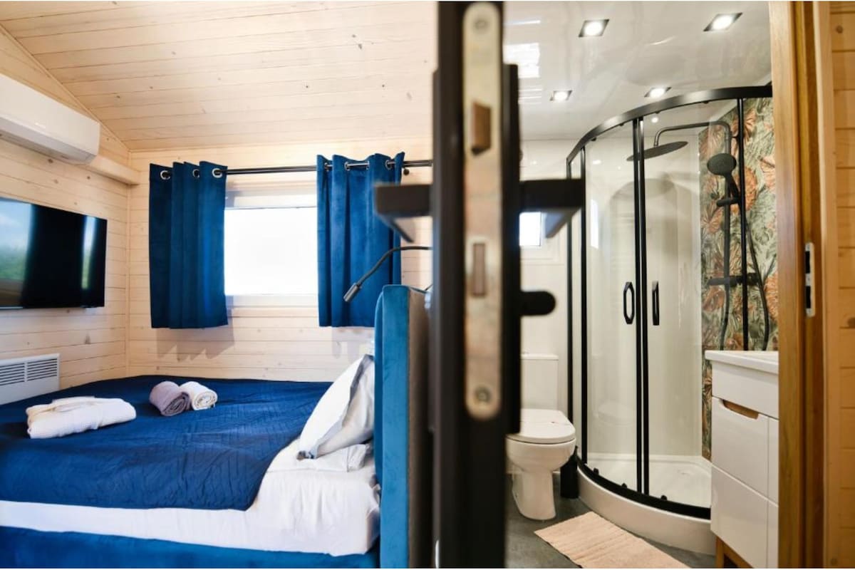 Ein modernes Zimmer mit Bett, Dusche und WC.