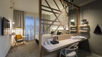 Une chambre d’hôtel moderne dotée d’un grand lit, d’un bureau avec un lavabo, d’une chaise, d’un miroir et offrant une vue sur la ville grâce à de grandes fenêtres.