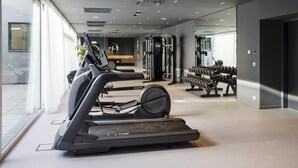 A modern gym with treadmills, weight machines, and dumbbells. - ARCOTEL AQ Wien (Vienna)