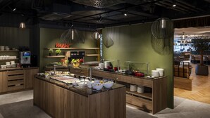 A modern breakfast bar with a variety of food items and a coffee machine. - ARCOTEL AQ Wien (Vienna)
