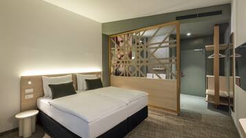 Ein modernes Hotelzimmer mit Bett, Nachttisch und einer Holzwand mit geometrischem Muster.