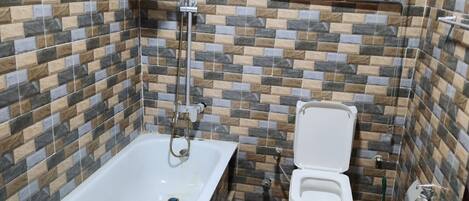 A bathroom with a bathtub, toilet, and shower.