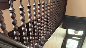 Een houten trap met een balustrade, leidend naar een deur met een raam.