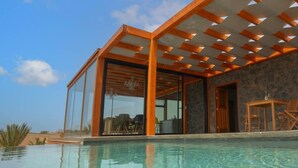 A modern house with a glass-enclosed patio and a swimming pool. - Casa Julie, Ferien in Absoluter Ruhe (La Pared)