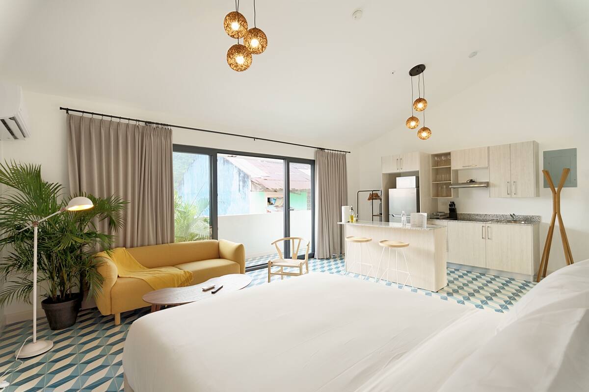 Ein Hotelzimmer mit Bett, Sofa, Essbereich und Küche.