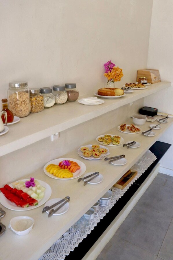 A buffet setup with various food items and condiments on shelves.