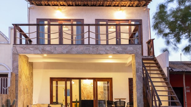 A two-story building with a balcony, a staircase, and a reception area with seating.