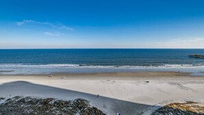 A beach with a pier extending into the ocean, sandy beach, and clear blue sky. - Blue Ocean Front Escape (MYRTLE BEACH)
