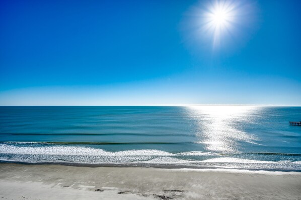 A beach with a clear sky and calm sea.