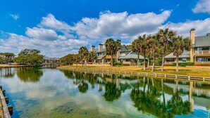A waterfront property with a clear lake, reflecting the surrounding buildings and trees. - Ocean Front Crown New Remodel (MYRTLE BEACH)