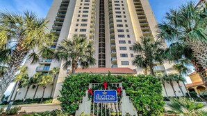 Un hotel moderno con numerosi balconi, circondato da palme e con una targa che indica 'The Brighton at Kingston Plantation'.
