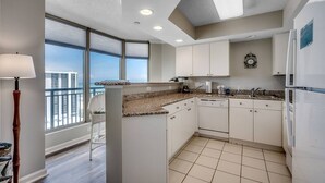 Una cucina moderna con mobili bianchi, piani in granito e vista sulla città.
