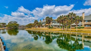 Um imóvel à beira-mar com um lago límpido, refletindo os edifícios e árvores ao redor.
