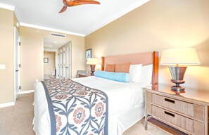 A hotel room with a bed, bedside lamps, a nightstand, and a ceiling fan.